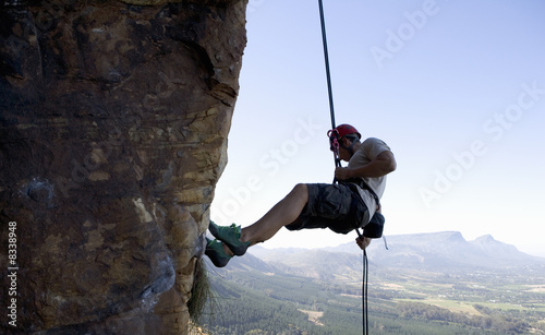 Photo: A climber climbing a rock face A climber climbing a rock face