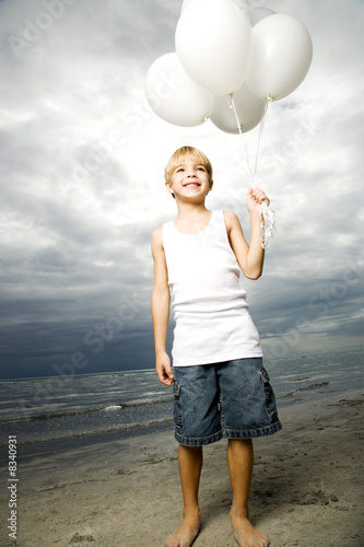 Photo: A young boy with a bunch of balloons A young boy with a bunch of balloons