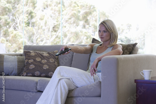 Photo: A woman using a remote control A woman using a remote control