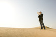A young man standing in the desert with a loud hailer