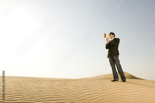 Foto: A young man standing in the desert with a loud hailer A young man standing in the desert with a loud hailer