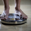 A young man standing on scales