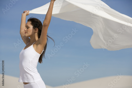 Photo: A young woman standing in the desert with a sheet A young woman standing in the desert with a sheet