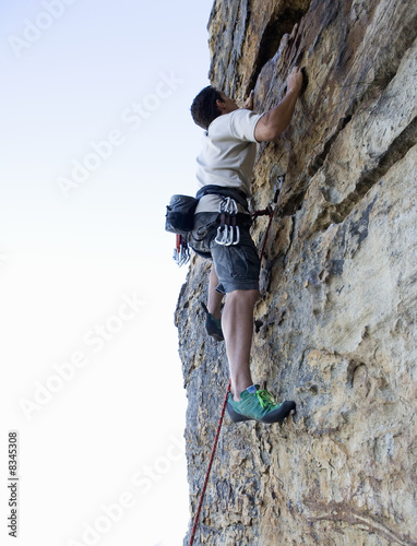 Photo: A climber climbing a rock face A climber climbing a rock face