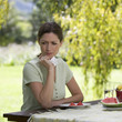 A woman looking sad and pensive sitting in the garden