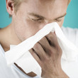 A young man blowing his nose