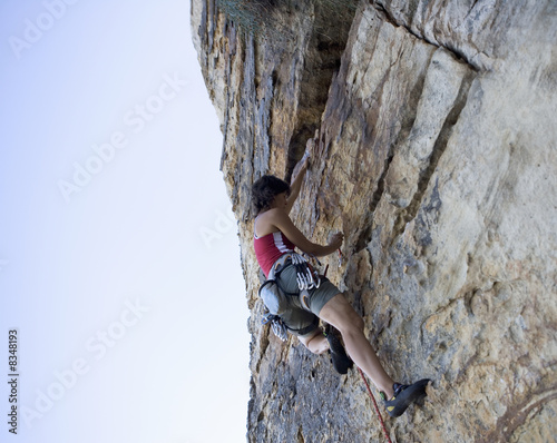 Photo: A climber climbing a rock face A climber climbing a rock face
