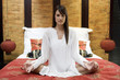 A woman sitting on a bed meditating