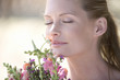 A young woman sniffing a bouquet of flowers, close-up