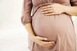 A pregnant woman holding her bump