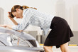 A businesswoman leaning on the bonnet of a car