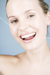 A young woman flossing her teeth