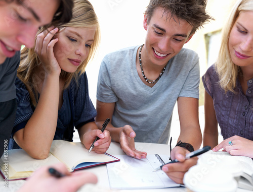 Photo: Young boys and girls sitting together with notes Young boys and girls sitting together with notes