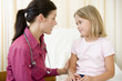Doctor giving checkup to young girl in exam room