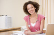 Doctor with laptop in doctor's office smiling