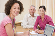 Doctor with laptop and couple in doctor's office smiling