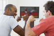 Two men in living room watching television and cheering