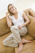 Woman in living room listening to MP3 player smiling