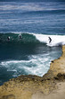 Central California surfer and withered cliff.