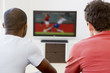 Two men in living room watching television