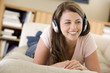Woman in living room listening to headphones smiling Woman in living room listening to headphones smiling