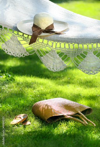 Foto: Straw hat with brown ribbon laying hammock Straw hat with brown ribbon laying hammock
