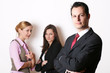Photo: successful business man in front of two business women successful business man in front of two business women