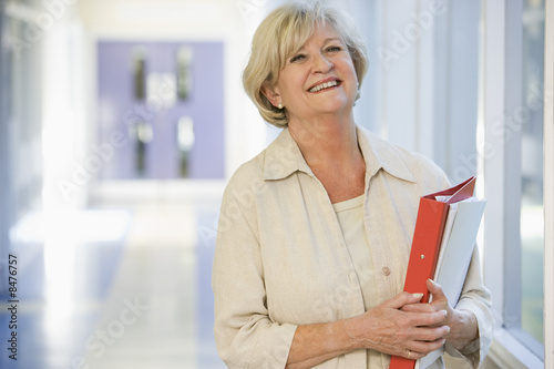 Photo: A woman with a ringbinder standing in a campus corridor A woman with a ringbinder standing in a campus corridor