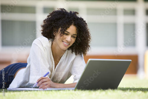 Photo: Woman using laptop on campus Woman using laptop on campus