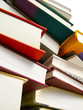 Various hardcover books stacked next to each other