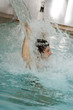 Young man standing under water spray in spa pool