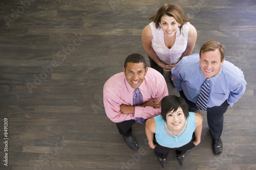 Photo: Four businesspeople standing and smiling Four businesspeople standing and smiling