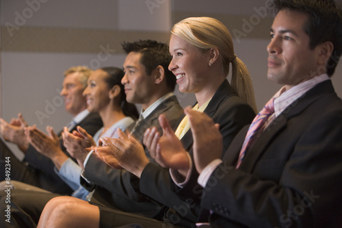 Five businesspeople applauding in presentation room