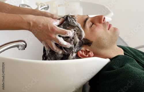 Photo: Young man having his hair washed at a salon Young man having his hair washed at a salon