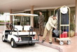 Bellboy delivering luggage to hotel with doorman standing by