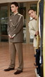 Bellboy delivering luggage to hotel with doorman standing by