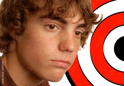 Photo: teenage boy with target behind his head - concept of bullying teenage boy with target behind his head - concept of bullying