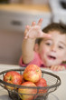 Young boy getting apple off counter