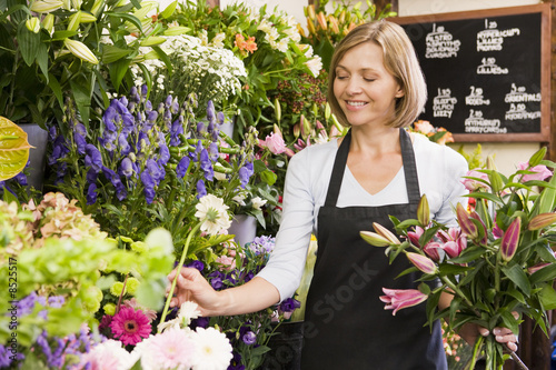 Photo: Woman working at flower shop smiling Woman working at flower shop smiling