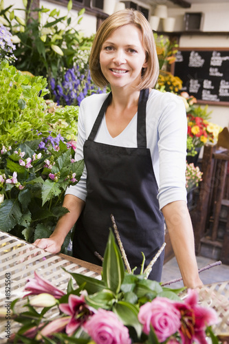 Photo: Woman working at flower shop smiling Woman working at flower shop smiling