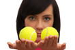 Girl holding two tennis balls on white