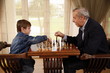 Mature man and little boy playing chess