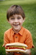 Little boy holding a hot dog