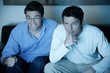 Two men watching a game on television