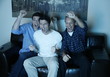 Three men watching a game on television