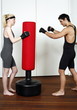 Young man and woman practicing with a punching bag