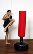 Young man kicking a punching bag