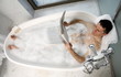 Man relaxing in bathtub with bubbles