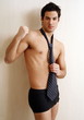 Bare chested young man posing with shorts and tie
