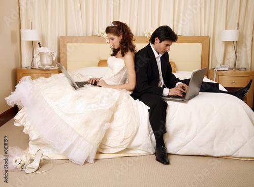 Photo : Bride and groom on laptops Bride and groom on laptops
